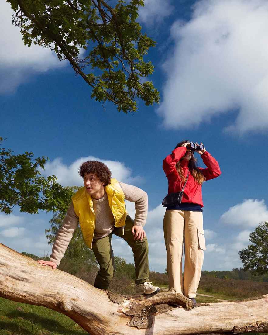 Een stel staat in de bossen om vogels te spotten met een verrekijker