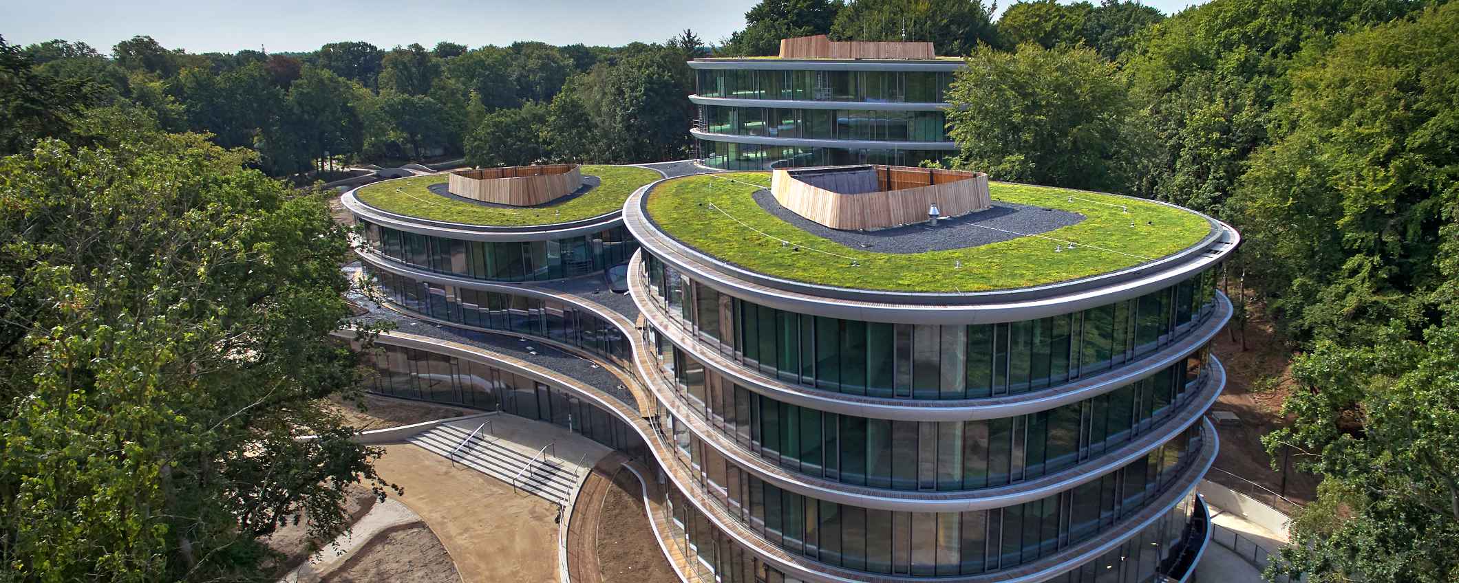 Het kantoor van Triodos Bank, de Reehorst, staat midden in het groen. Het gebouw heeft ronde vormen, veel glas en daken met planten.