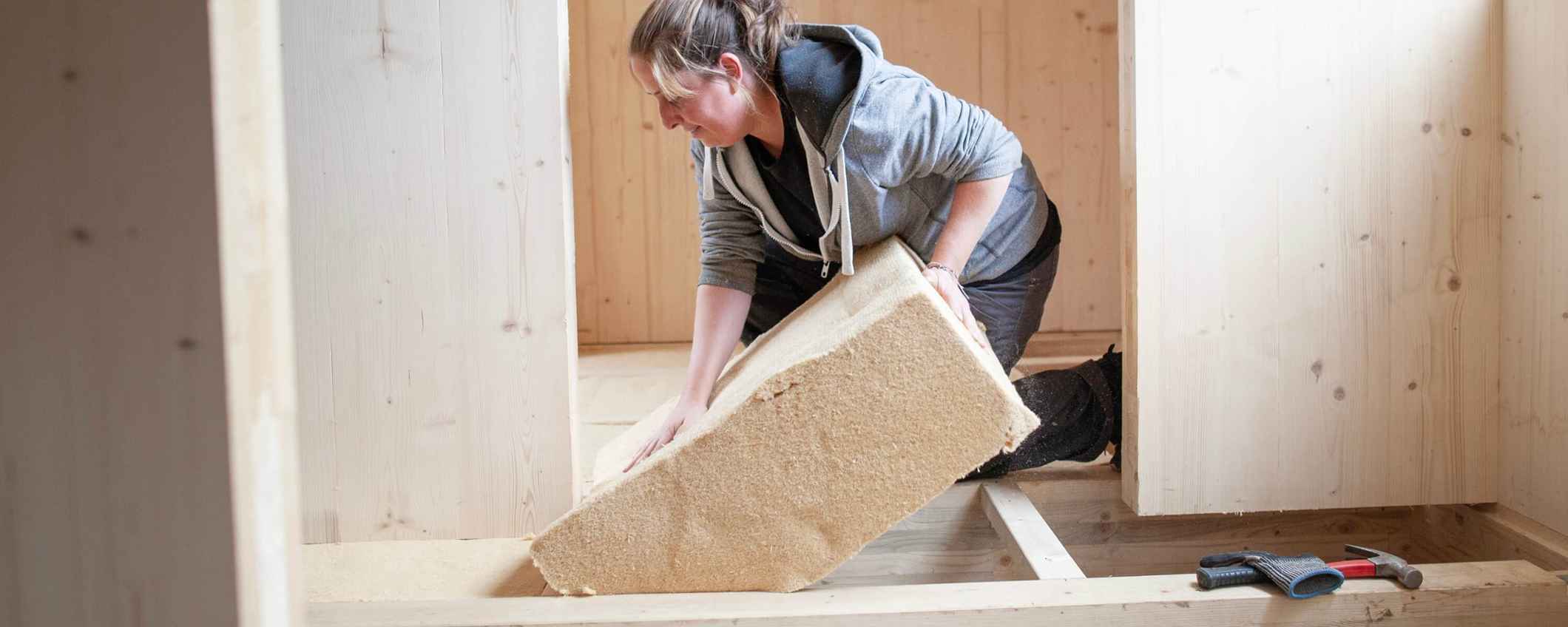 Een vrouw klust aan een huis voor de tiny house community Op de Bees