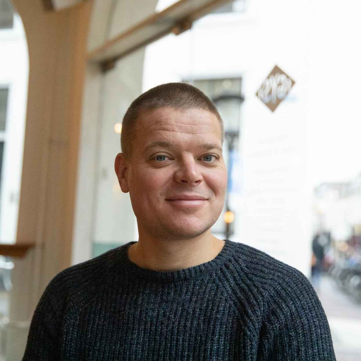 Man staat in het restaurant GYS. Hij is de eigenaar van het restaurant en klant van Triodos Bank.