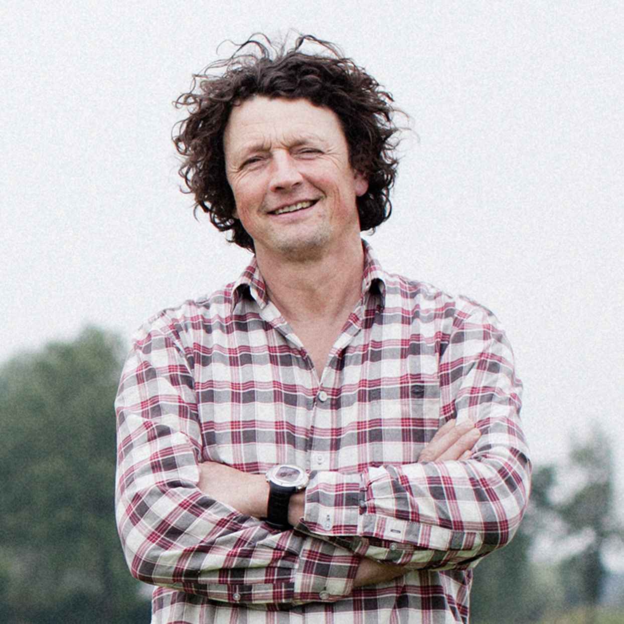 Man in een weiland vol koeien. Hij is mede-eigenaar van zorgboerderij De Hondspol en klant van Triodos Bank.